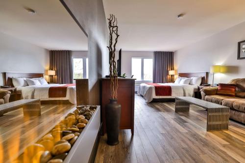 Habitación de hotel con 2 camas y sala de estar. en Comfort Inn & Suites, en Saint-Jérôme