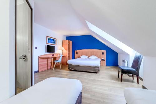 a bedroom with a bed and a desk in a room at Comfort Hotel Evreux in Évreux