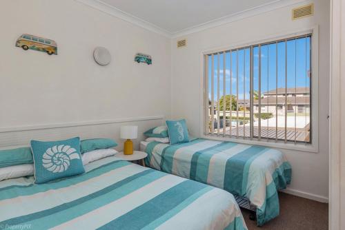 1 dormitorio con 2 camas y ventana con vistas en Jamaica Holiday Units, en Forster
