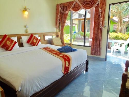 a bedroom with a bed and a large window at Blue Andaman Lanta Resort in Ko Lanta