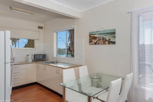 a kitchen with a table and a refrigerator at Jamaica Holiday Units in Forster