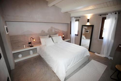 a bedroom with a large white bed and a mirror at Casa Nostra Luxury Suites & Spa in Palermo