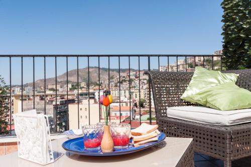 ein Tablett mit Speisen auf einem Tisch auf einem Balkon in der Unterkunft Attico Oltremare B&B in Neapel