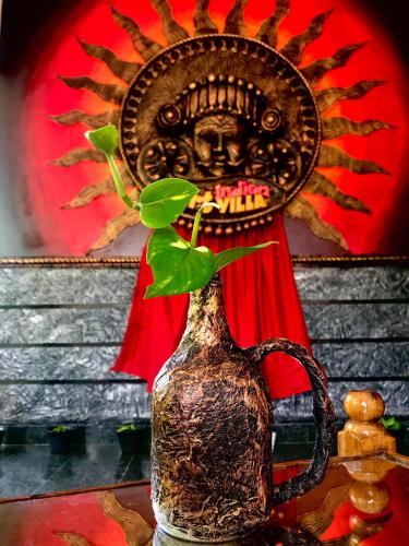 a vase with a plant in it on a table at Indian Art Villa in Varkala