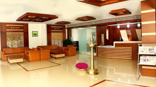 a lobby of a building with furniture and a room with a lobby at Hotel Emerald Regency in Putuppalli