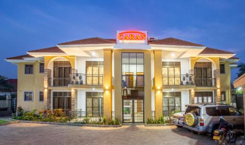 un coche aparcado delante de un edificio en Caran Apartments, en Kampala