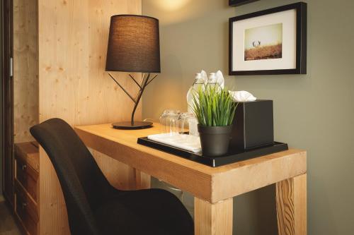 a desk with a chair and a lamp on it at Boutique Hotel Sunrose 7 - Gourmet & SPA in Bohinj