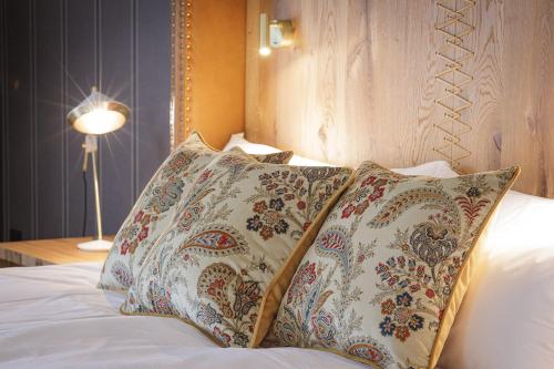 a bedroom with a bed with pillows and a lamp at Boutique Hotel Sunrose 7 - Gourmet & SPA in Bohinj