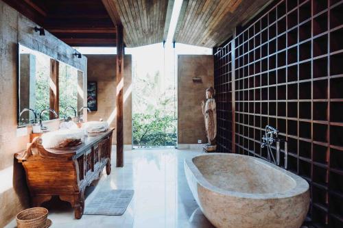 een badkamer met een groot bad en 2 wastafels bij Dragon House - Your Dream House in Bali! in Ubud