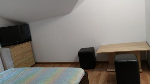 a bedroom with a bed and a desk and a tv at Самостоятелен етаж от къща за гости in Haskovo