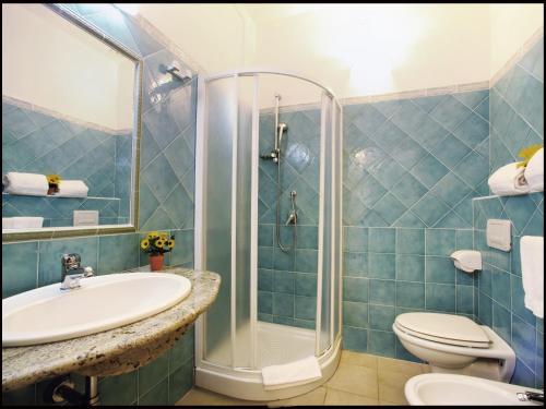 a bathroom with a shower and a sink and a toilet at Albergo Residenziale Gli Ontani in Cala Liberotto