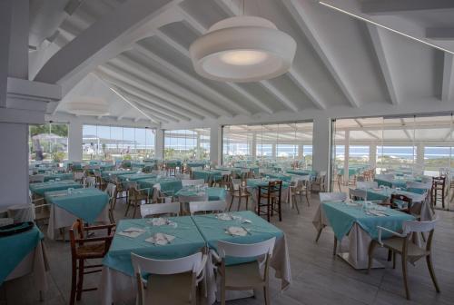 a banquet hall with blue tables and chairs at BV Kalafiorita Resort in Zambrone