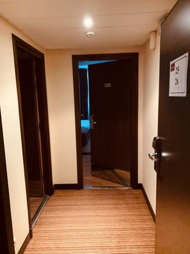 an empty room with a door and a mirror at Hotel Mercure Rennes Cesson in Cesson-Sévigné