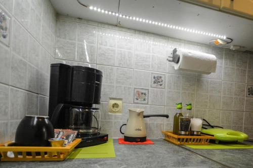 a kitchen counter with a coffee maker and a coffee pot at Andriannas apartment-parking lot included in Patra