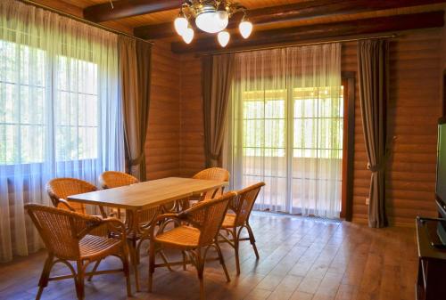 a dining room with a wooden table and chairs at Knyazhyi Dvir in Myslivka