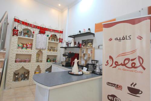 a kitchen with a counter and a sign in a room at شقق منازل القصواء للشقق المخدومة إقتصادي in Buraydah