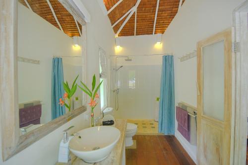 Trikora Beach Club and Resort في تيلوكباكاوْ: حمام مع حوض ومرحاض
