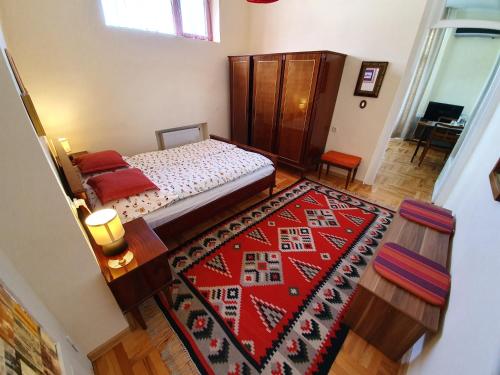 - une chambre avec un lit et un tapis rouge dans l'établissement Odo's House in Tsinandali, à Tsinandali