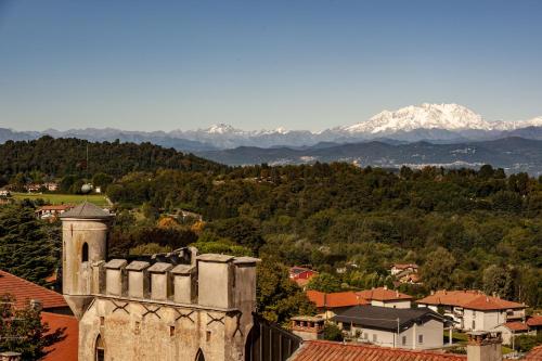 an old building in a town with mountains in the background at Hotel Locanda Dei Mai Intees in Azzate