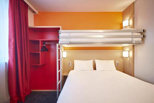 a bedroom with a bed and a window at Premiere Classe Clermont Ferrand Centre in Clermont-Ferrand