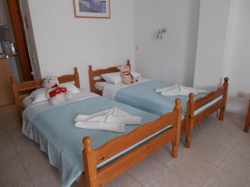 2 Betten mit ausgestopften Tieren auf einem Zimmer in der Unterkunft Mariliza Beach Hotel in Marmari