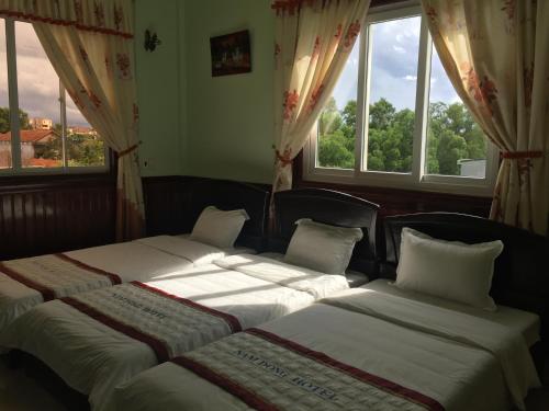 2 camas en una habitación con 2 ventanas en Khách sạn nam đông, en Quang Tri