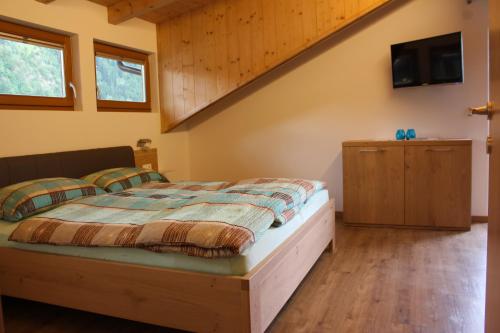 a bedroom with a bed and a tv on the wall at Appartements Pixner in Saltusio