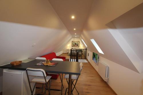 Cette chambre mansardée comprend une table et des chaises. dans l'établissement Chambre chez l'habitant - L Écureuil - Cœur de Riquewihr - 2 personnes, à Riquewihr