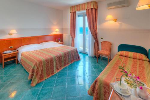 una camera d'albergo con due letti e un tavolo di Hotel Il Caminetto a Porto San Giorgio