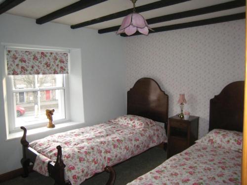 a bedroom with two beds and a window at Lark Cottage in Pickering
