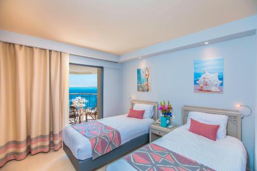 a bedroom with two beds and a balcony at Sunrise Holidays Resort -Adults Only in Hurghada