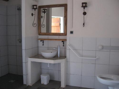 une salle de bain avec un lavabo et un miroir dans l'établissement Camping Mille Étoiles, à Labastide-de-Virac