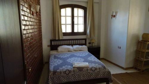 a bedroom with a bed with a blue and white blanket at Homestay Family near Luxor monuments in Luxor