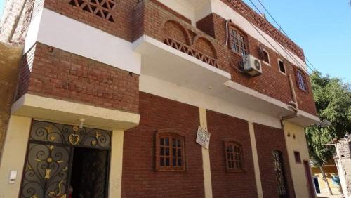 a red brick building with a door and a building at Homestay Family near Luxor monuments in Luxor