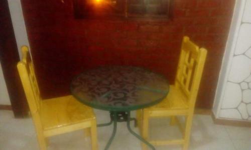 a table and two yellow chairs and a table and chairs at Homestay Family near Luxor monuments in Luxor