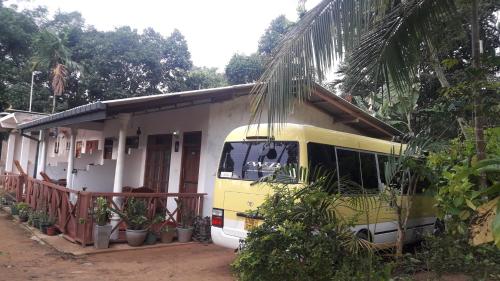 un autobus giallo parcheggiato davanti a una casa di Ella Infinity View a Ella