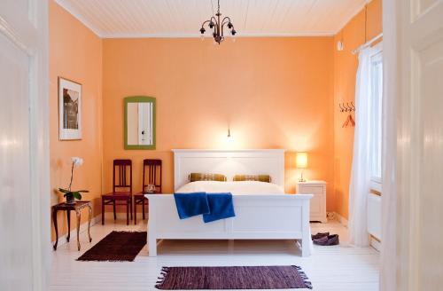 1 dormitorio con 1 cama blanca y paredes de color naranja en B&B Pinus, en Mäntyharju