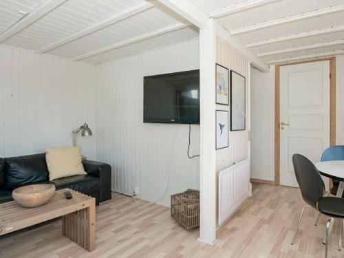 a living room with a black couch and a table at 4 person holiday home in Fan in Fanø