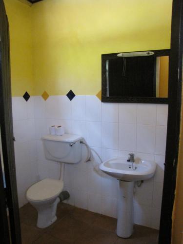a bathroom with a toilet and a sink at Kipepeo Beach and Village in Dar es Salaam