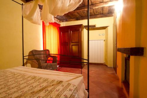 a bedroom with a bed and a chair in a room at La Locanda Dei Cartunè in Montezemolo