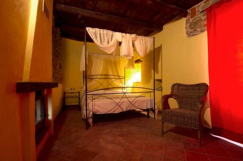 een slaapkamer met een hemelbed en een stoel bij La Locanda Dei Cartunè in Montezemolo