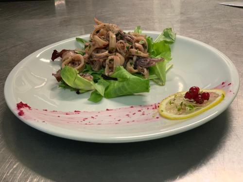 a plate of food with a salad on a table at Villa Liliana in Cervia