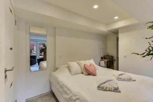 a bedroom with a bed with a mirror on the wall at Luxury Beach Studio Zandvoort in Zandvoort