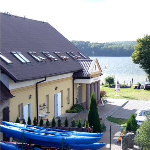 a building with boats lined up in front of it at Paradise in Charzykowy