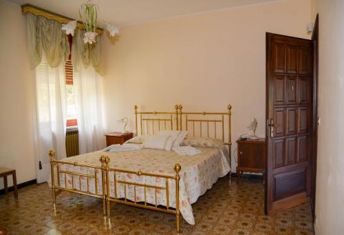 sypialnia z łóżkiem i drewnianymi drzwiami w obiekcie B&B Le Coccinelle w mieście Torre Bormida