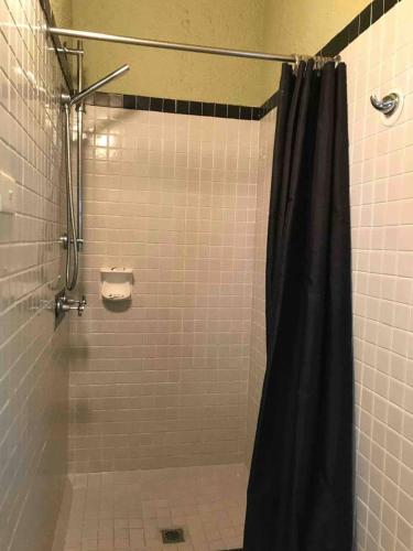 a shower with a black shower curtain in a bathroom at Casablanca Domes Trinity Beach in Trinity Beach