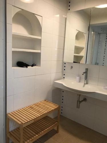 La salle de bains est pourvue d'un lavabo, d'un miroir et d'un banc. dans l'établissement VOILES ST TROPEZ APARTEMENTS, à Saint-Tropez