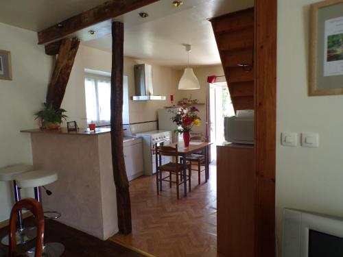 een keuken en een woonkamer met een tafel en stoelen bij Gite La Méluzine in Magny