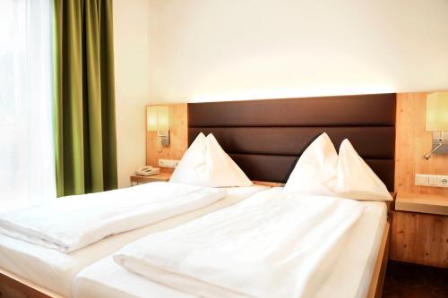 a bedroom with two beds with white sheets at Der Seebacherhof in Tauplitz