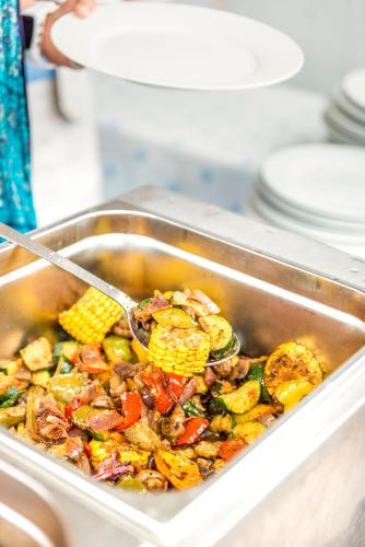 a pan of food with corn and a spoon in it at Der Seebacherhof in Tauplitz
